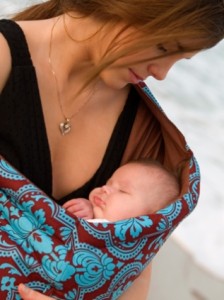 mother holding a baby in a baby sling